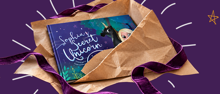 A personalised book, My Secret Unicorn, unwrapped from brown paper and purple ribbon
